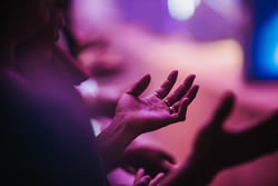 God's grace shown to a woman with hands out in worship