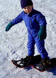 young boy trying snow shoes