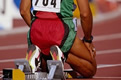 runner kneeling in front of starting blocks