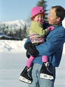 Dad holding child ice-skater